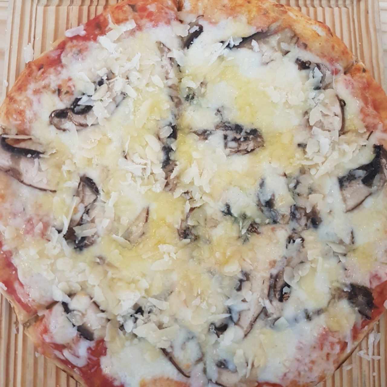 pizza con hongos provolone parmesano y aceite de trufa