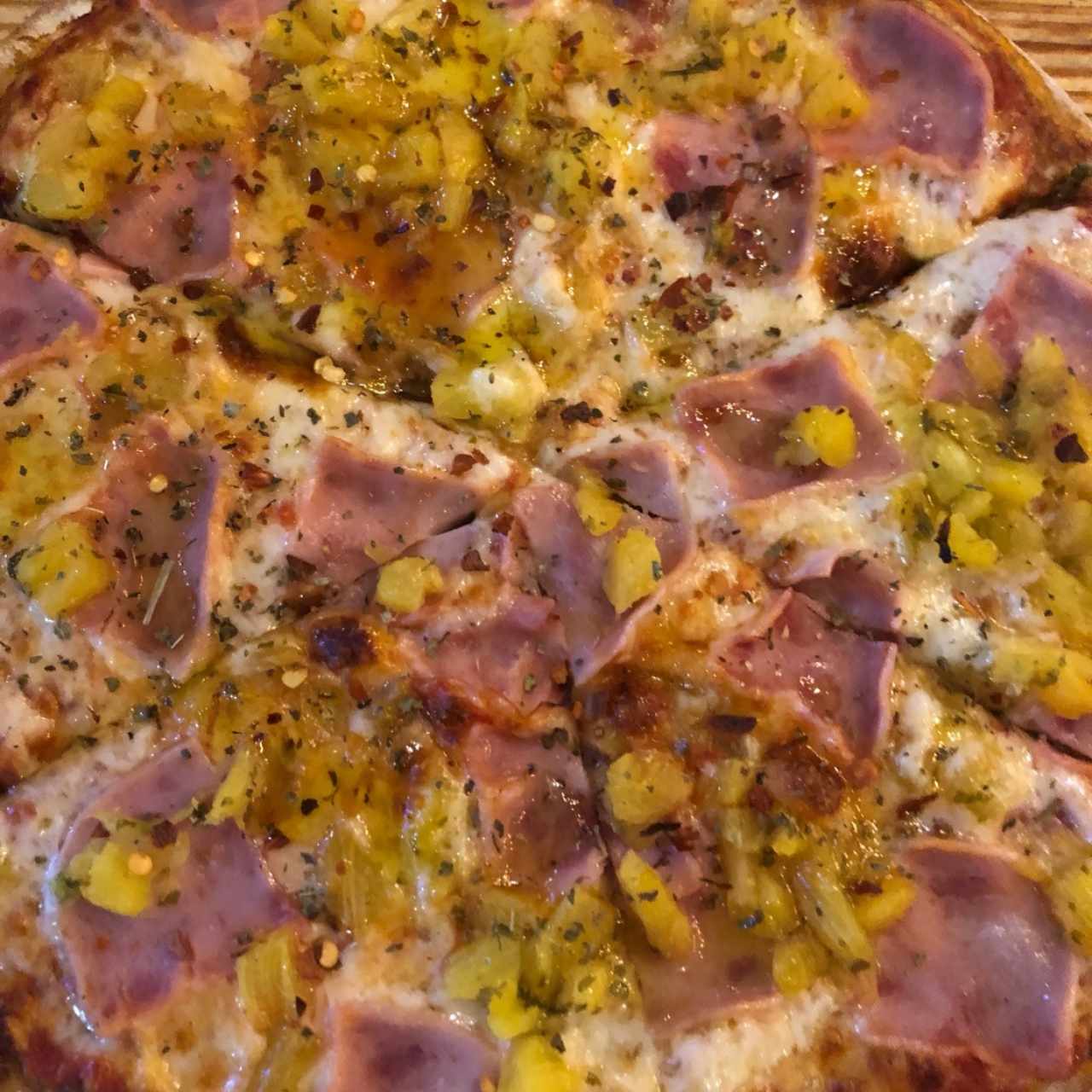Pizza Hawaiana con masa de fresa con albahaca y rociada con aceite de oliva, pimienta roja y oregano