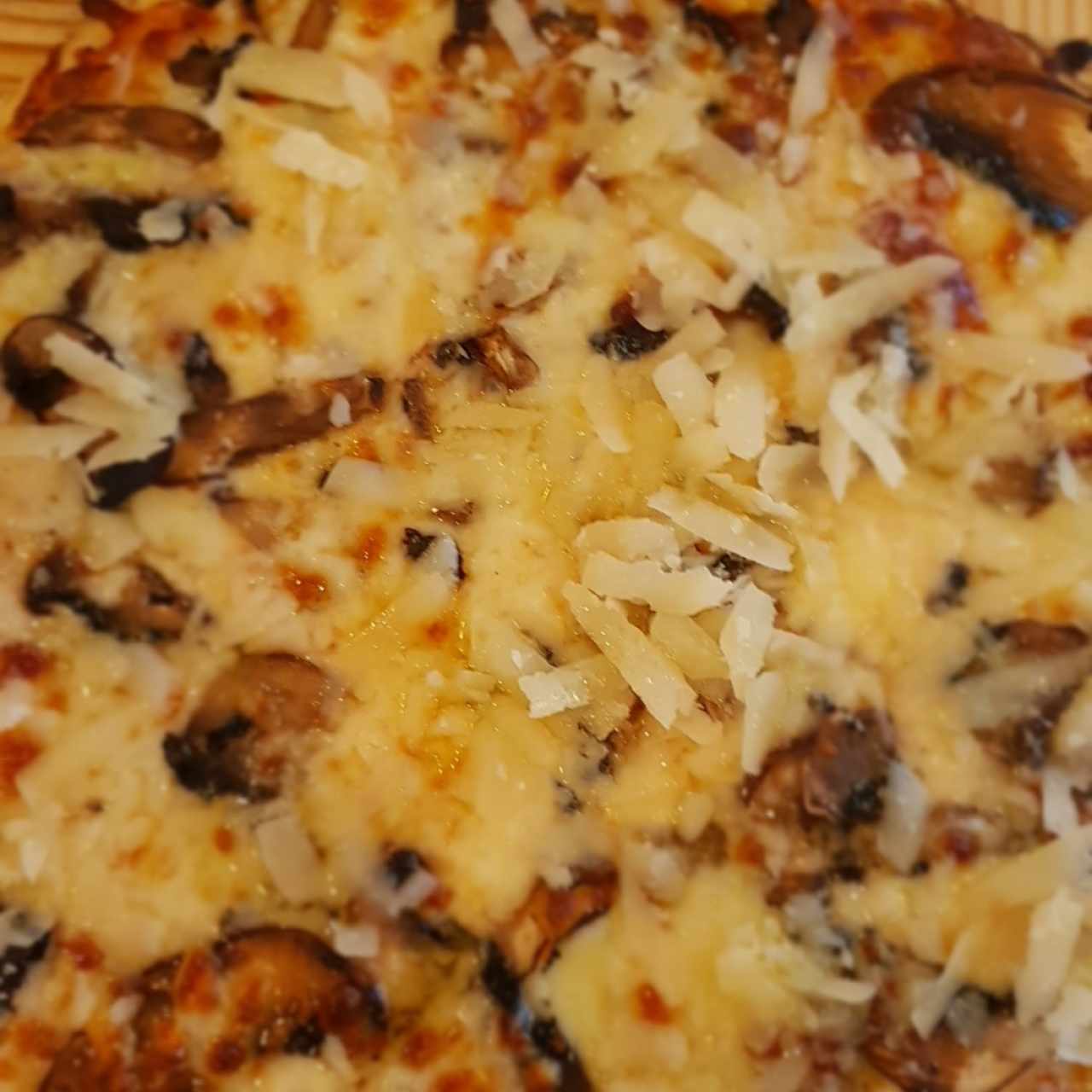 Pizza de cogumelos con queso provolone y aceite trufado