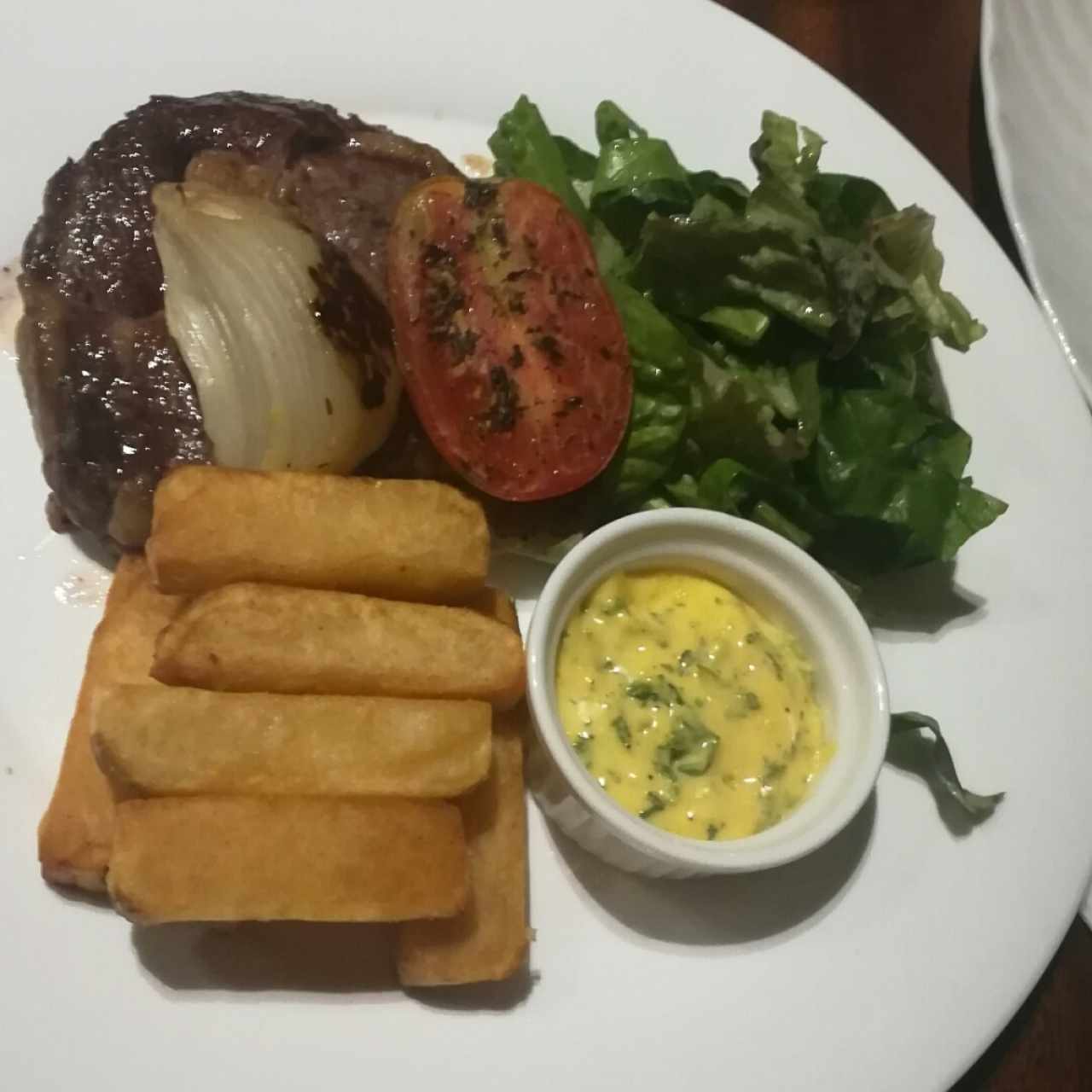 Rib-eye steak (10oz), papas chunky, tomate horneados, cebolla rostizada, salsa Bernaise y mix de lechugas