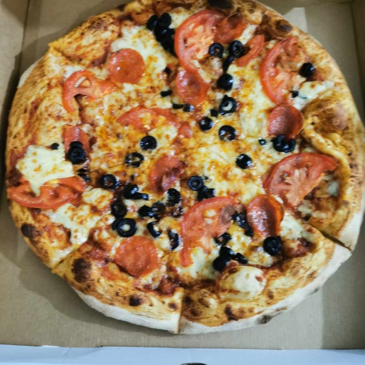Pizza de peperoni, tomate, aceitunas negras