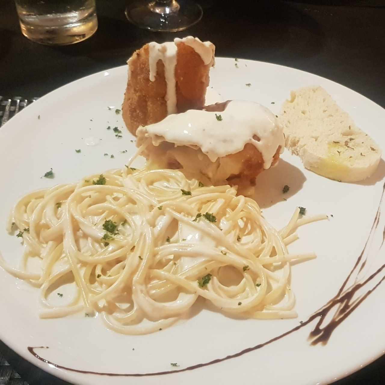 Pollo a la Parmigiana, con espaguetti en salsa de queso de la casa.