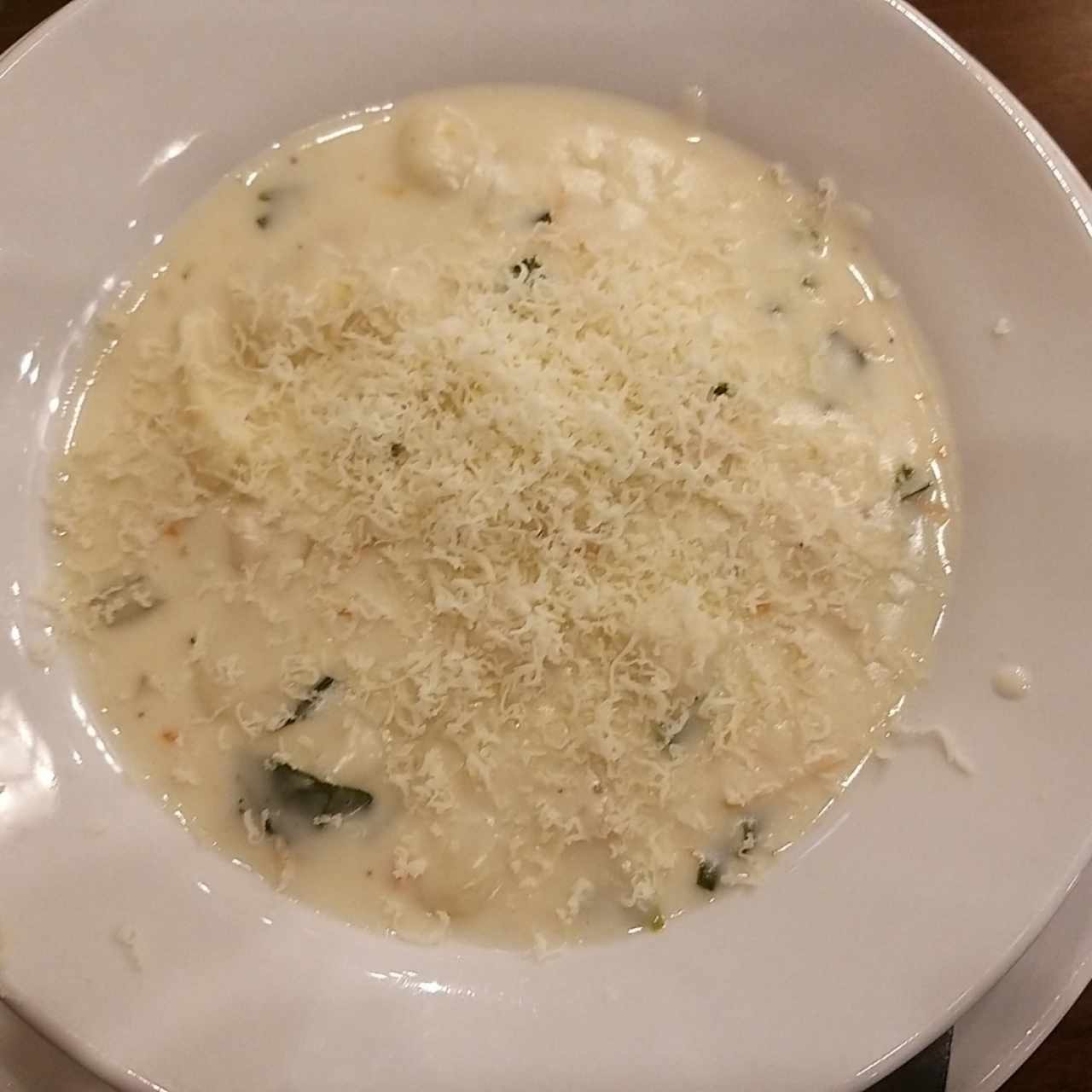 sopa con ñoquis y pollo bañada con queso parmesano