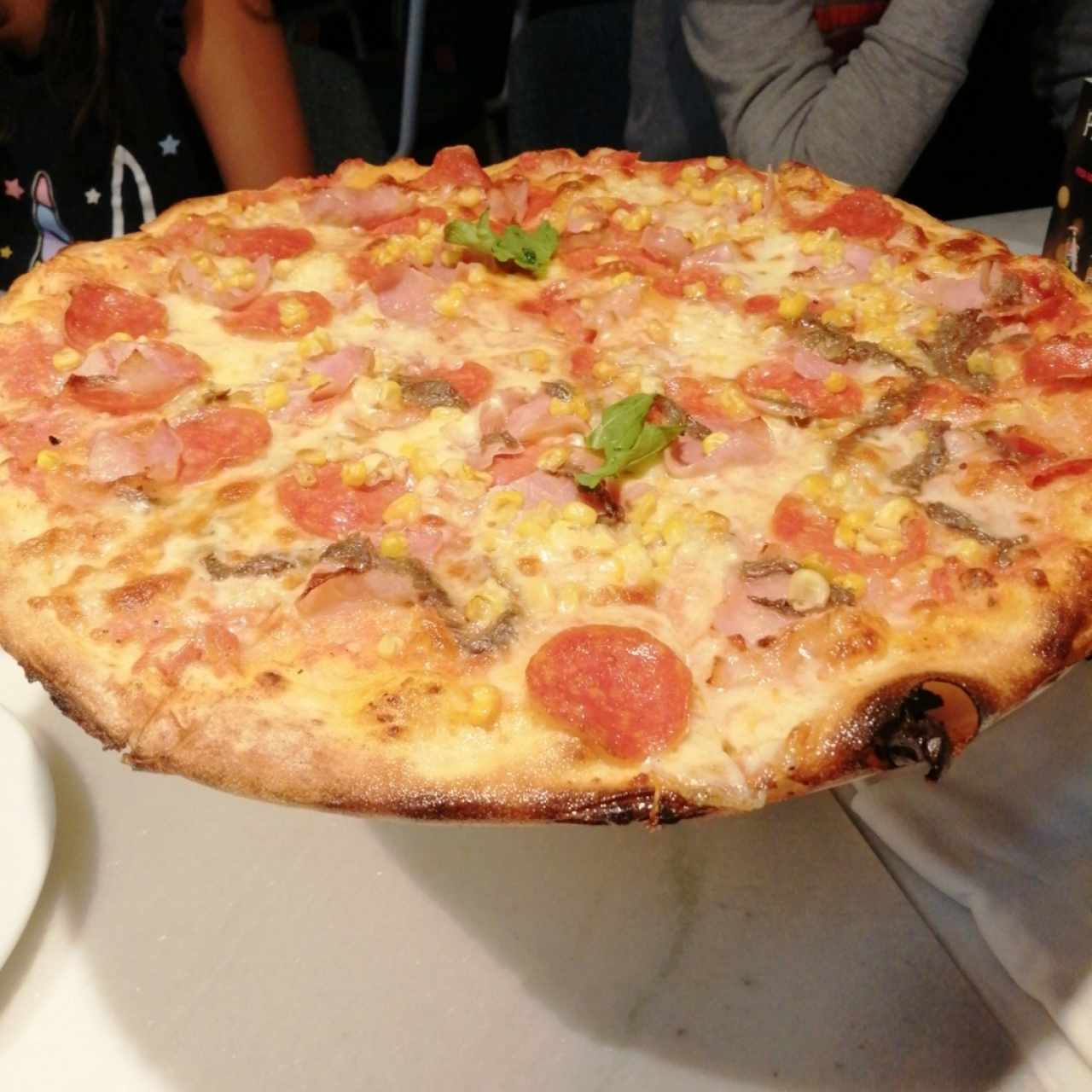 Pizza Rosa, anchoas, peperoni, jamón y maiz