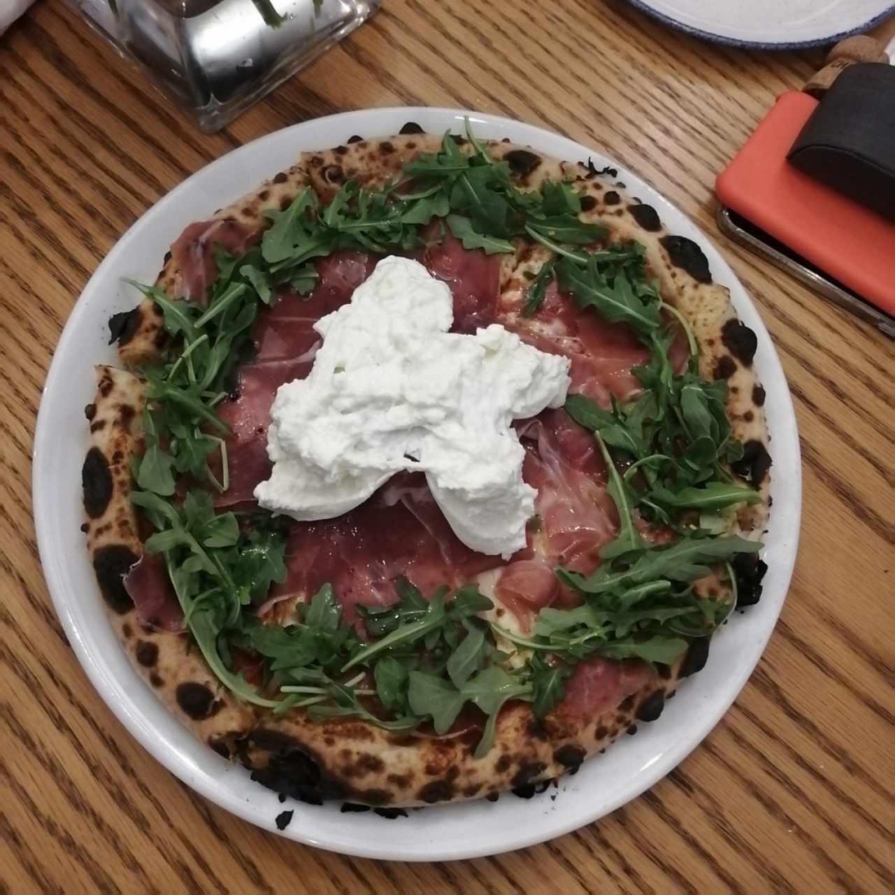 Pizza napolitana con arugula, jamón serrano y burrata