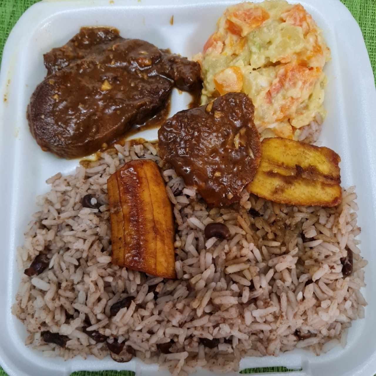Lengua al vino con arroz con coco y frijolitos chiricanos, ensalada de pspas y platano maduro