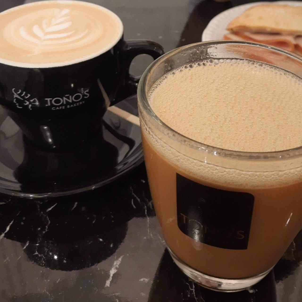 Café filtrado con aceite de coco, mantequilla orgánica y ralladura de limón (der). Cappucino regular (izq)