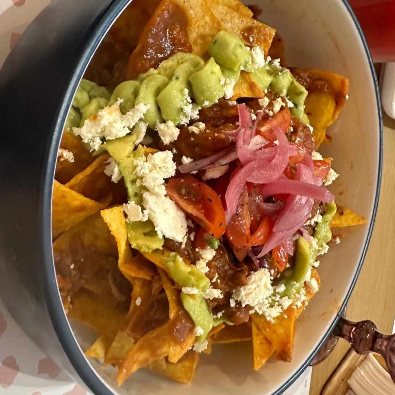 BIRRIA CHILAQUILES (Nachitos bañados con birria de res, crema, maíz dulce. topping de cilantro y quesito)