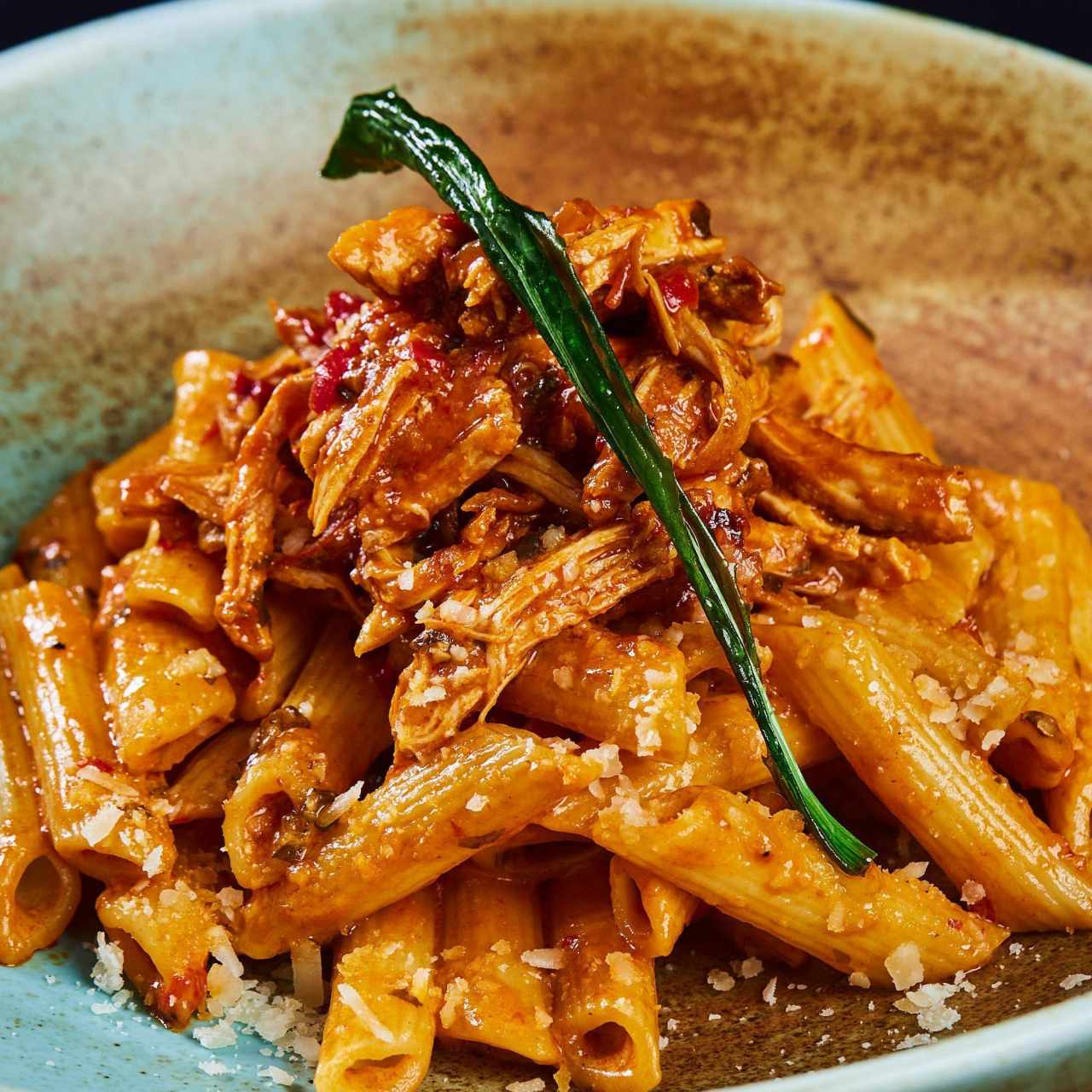 Pasta al estilo panameño con cremoso estofado de pollo y un toque de queso parmesano