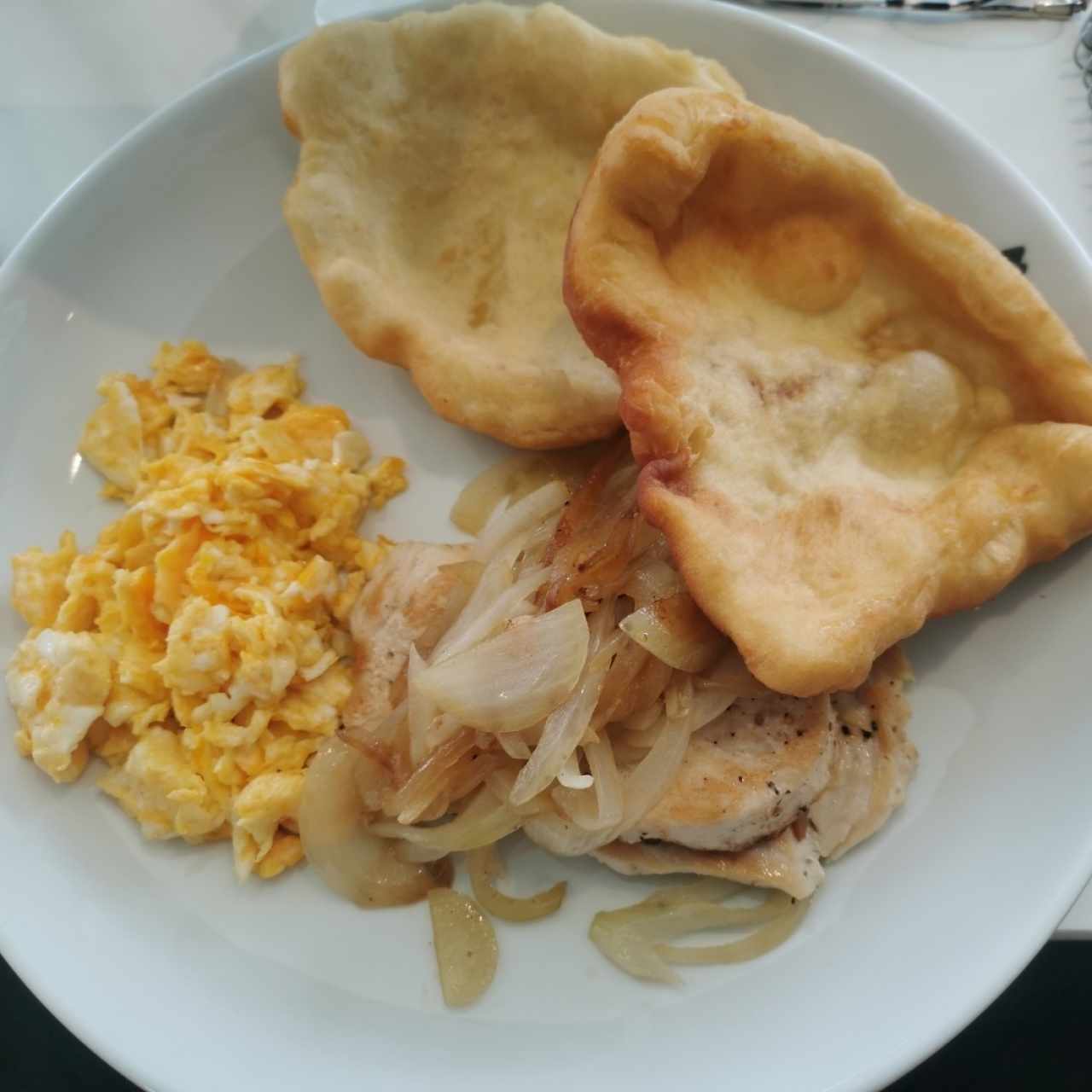 Desayuno panameño: Filete de pollo encebollado con hojaldre y huevos revueltos 