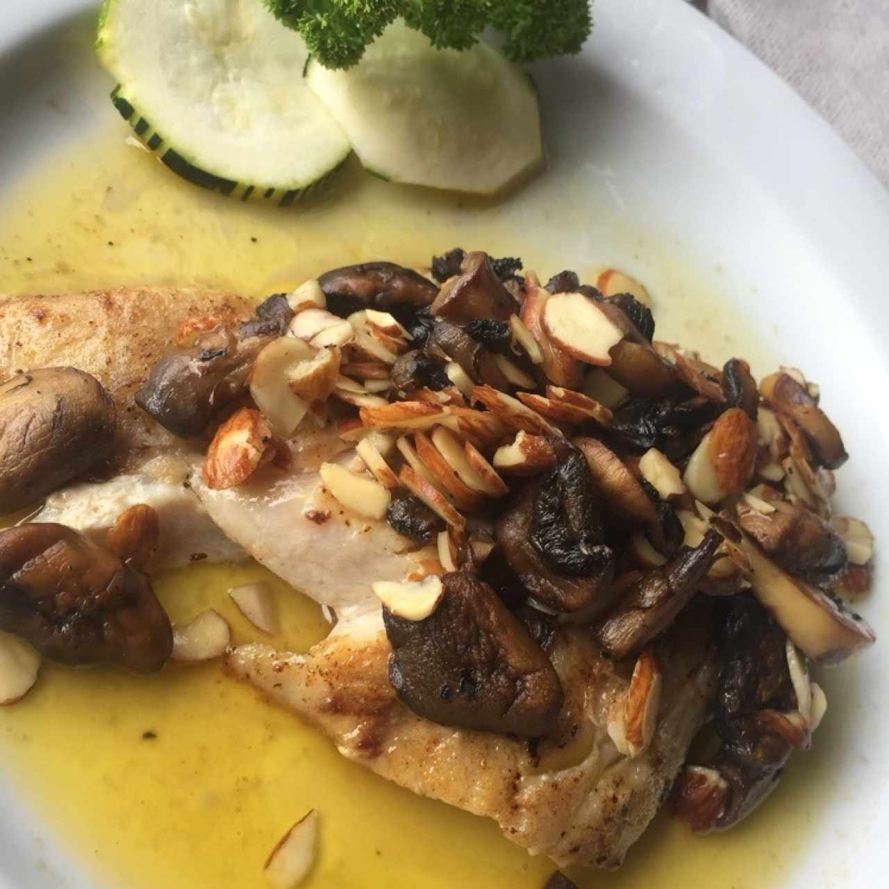 corvina bañado en champiñones y almendras