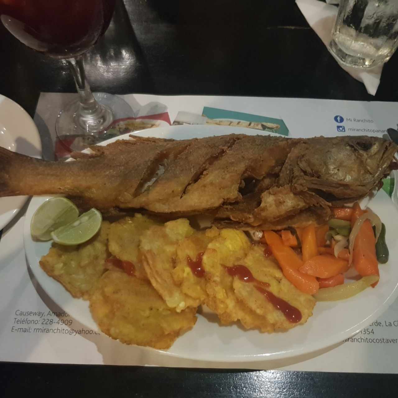 Pescado entero frito acompañado de patacones y ensalada