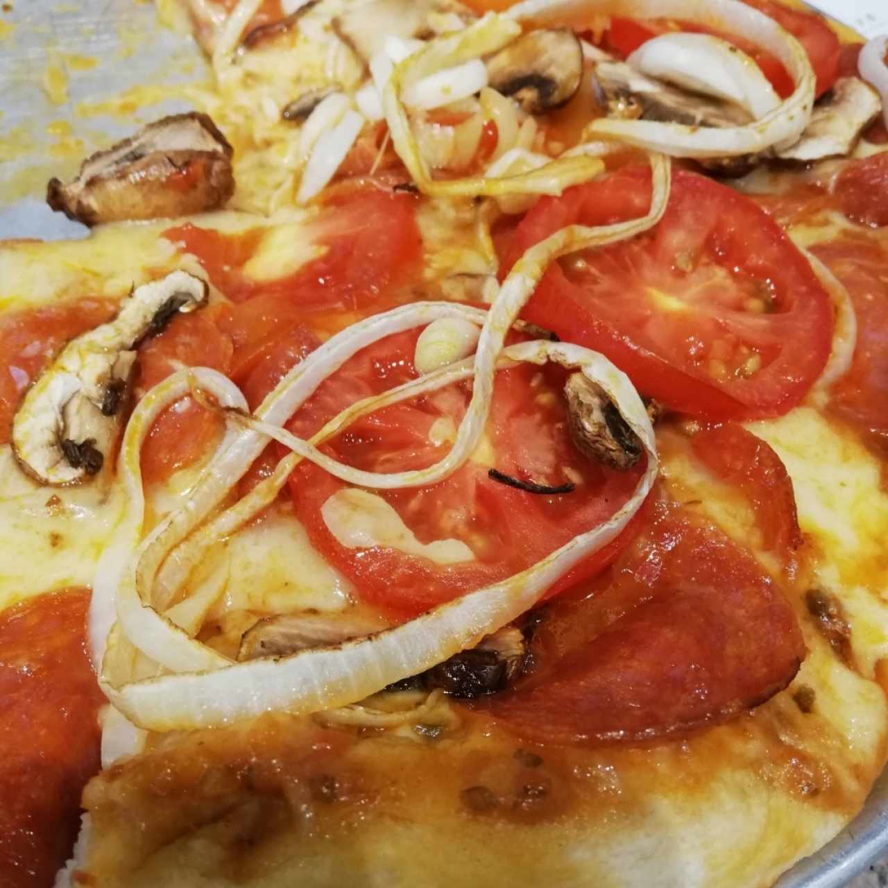 pizza de peperoni, cebolla y tomate fresco