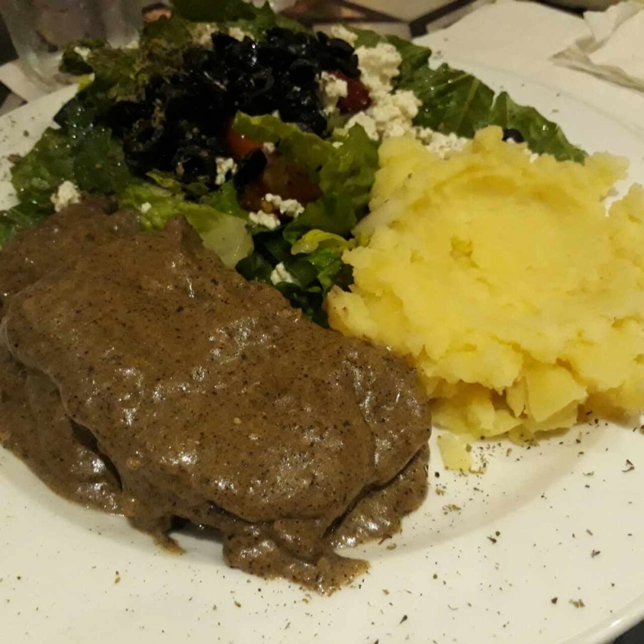 Filete de res a la pimienta; acompañado de puré de papas y ensalada gierga.