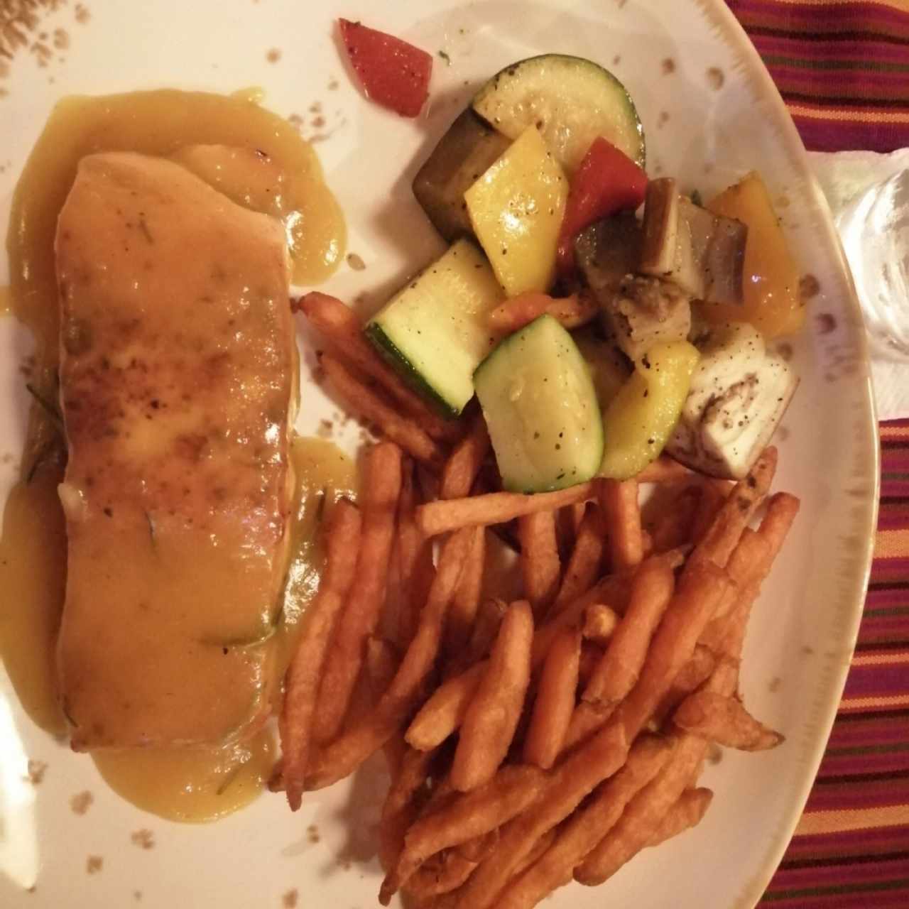 Salmon en Salsa Reducida de Maracuyá con tiras de camote frito y vegetales salteados. 