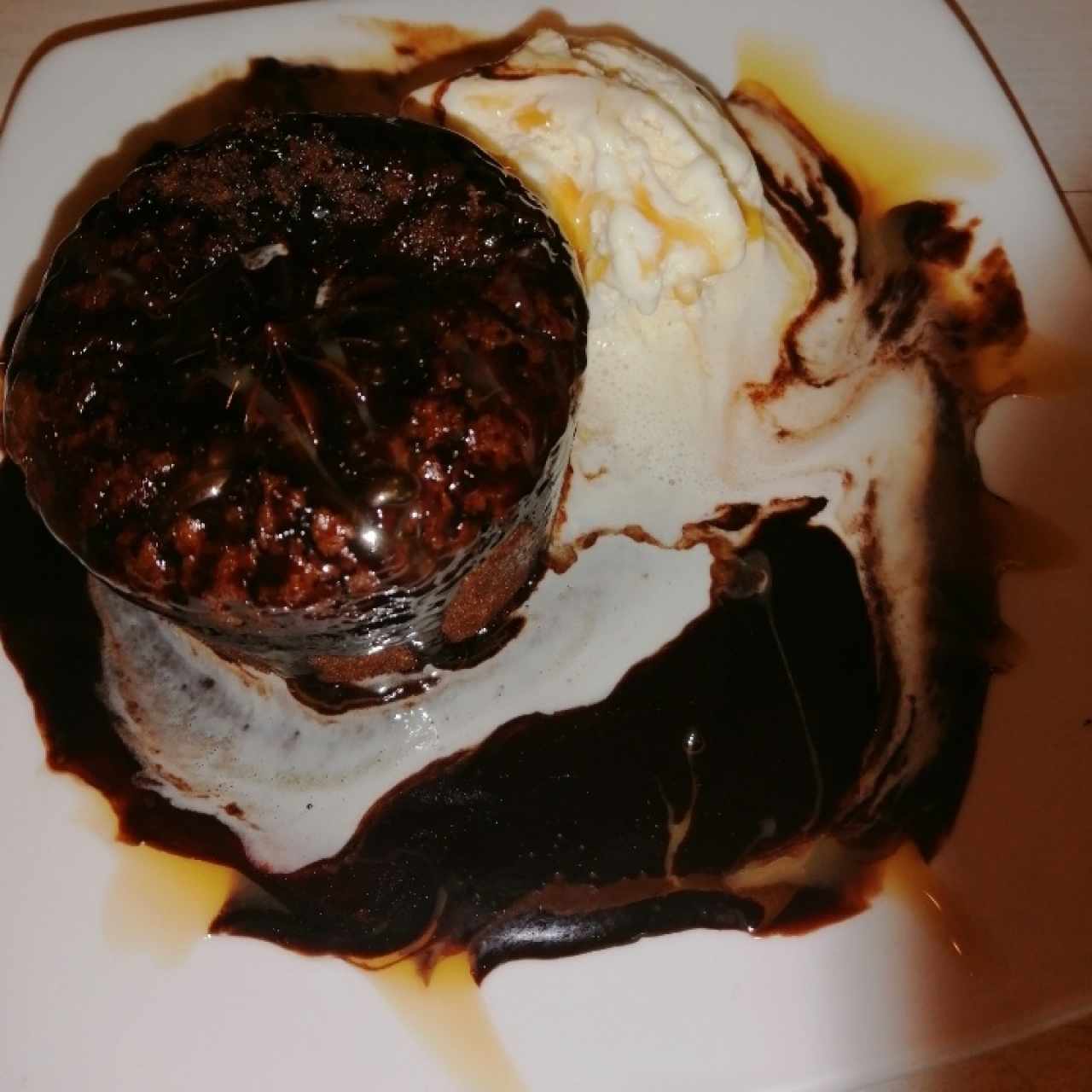 Muffin de chocolate volcán con crema de chocolate caliente en cama de helado 