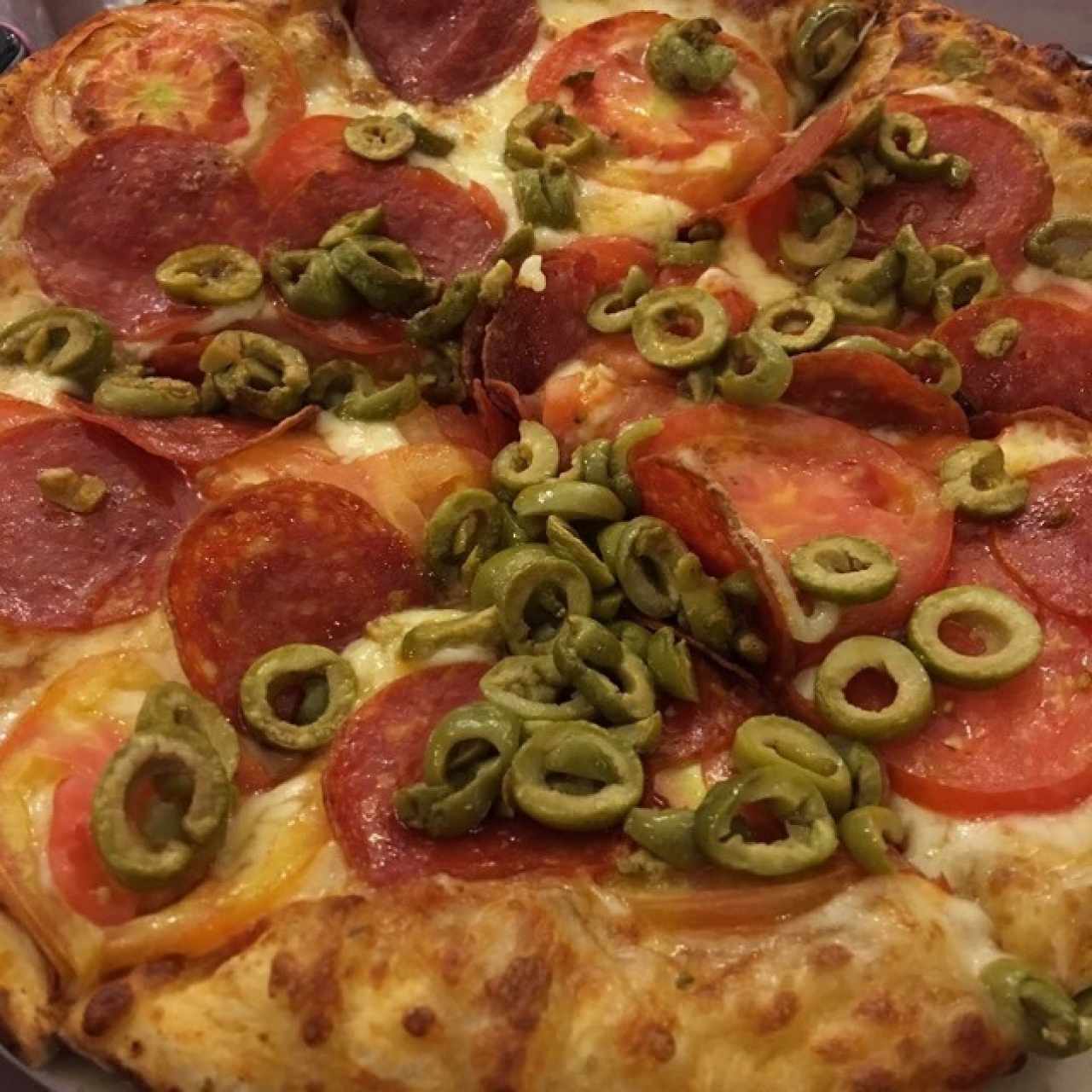 Pizza de pepperoni, aceitunas verdes y tomate