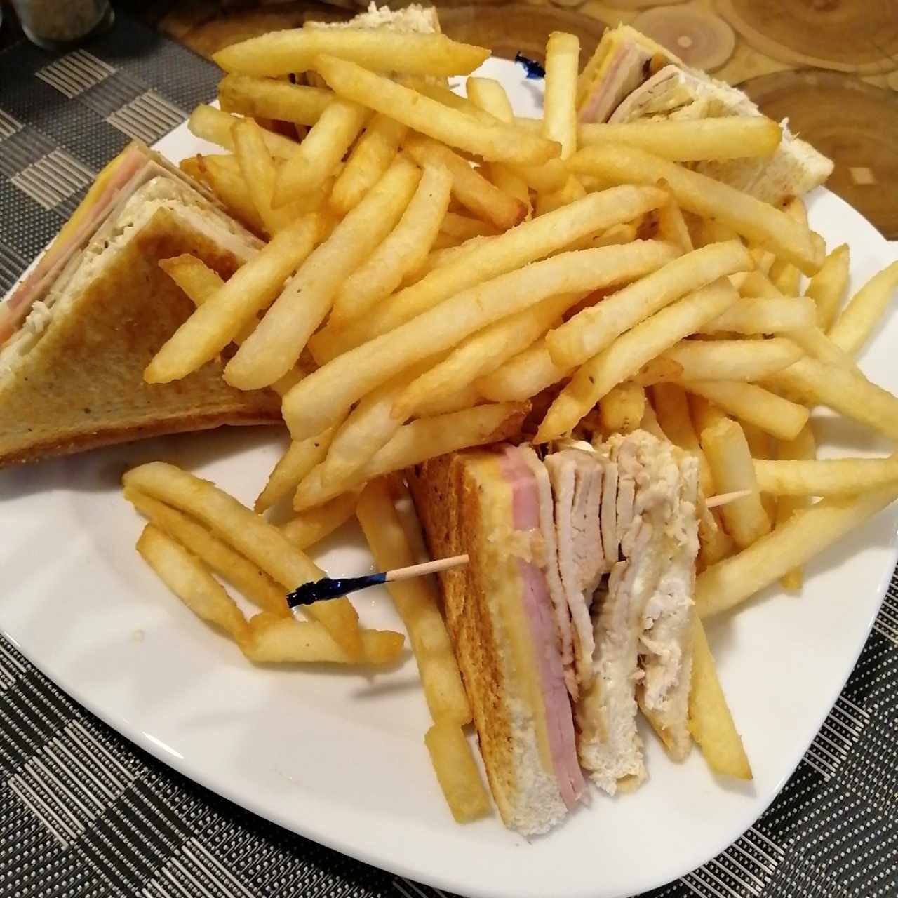 club sandwich con papas fritas.