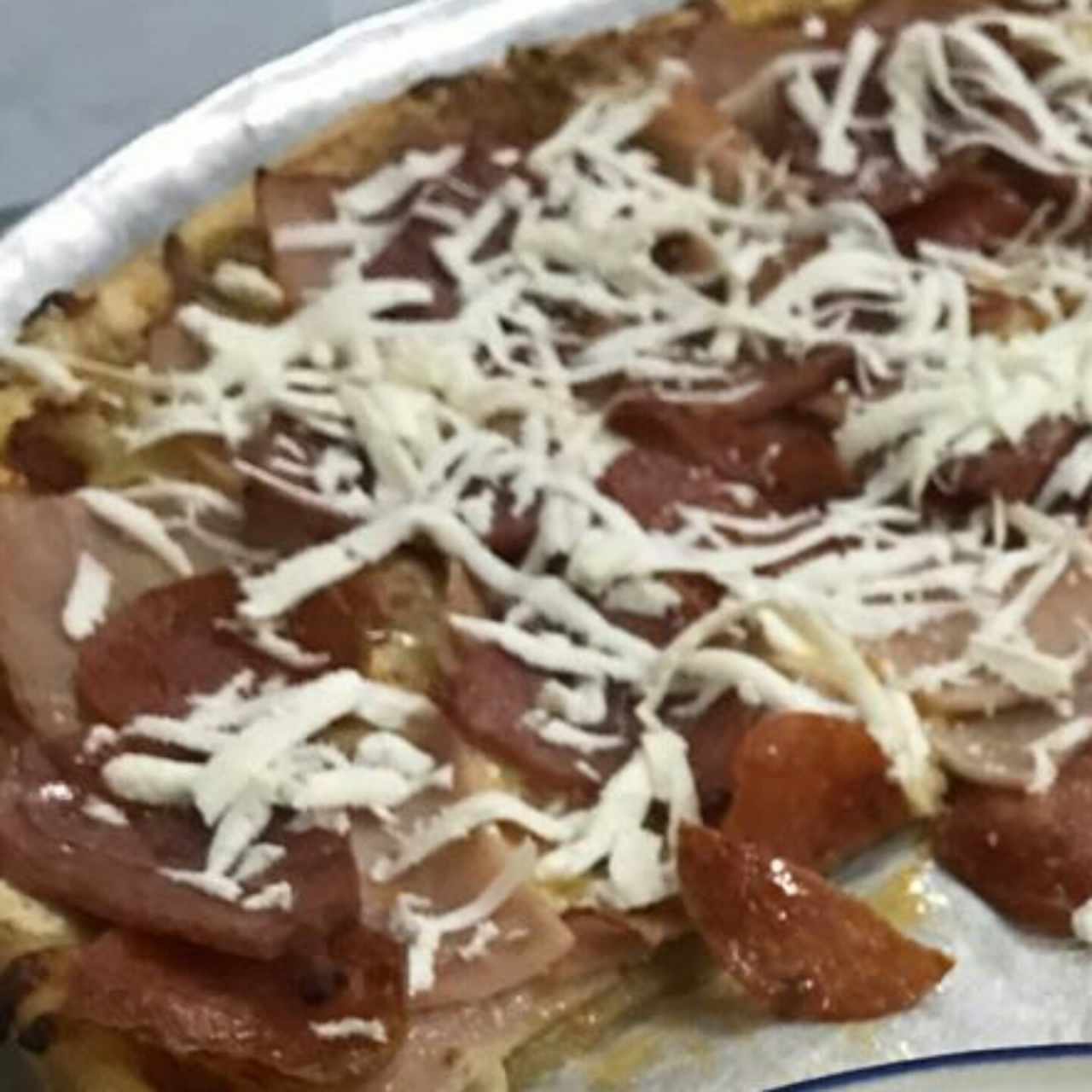 pizza con pepperoni y jamon con queso feta.