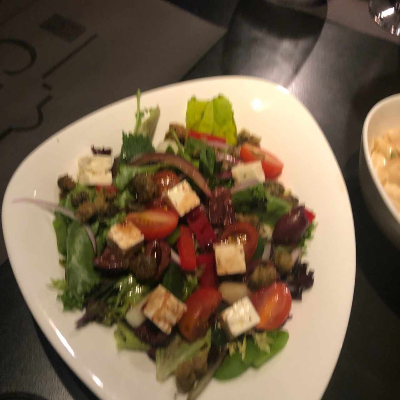 Ensalada greta, mezclum de lechugas, queso feta, tomate cherry, kalamasta y aderezo mediterraneo