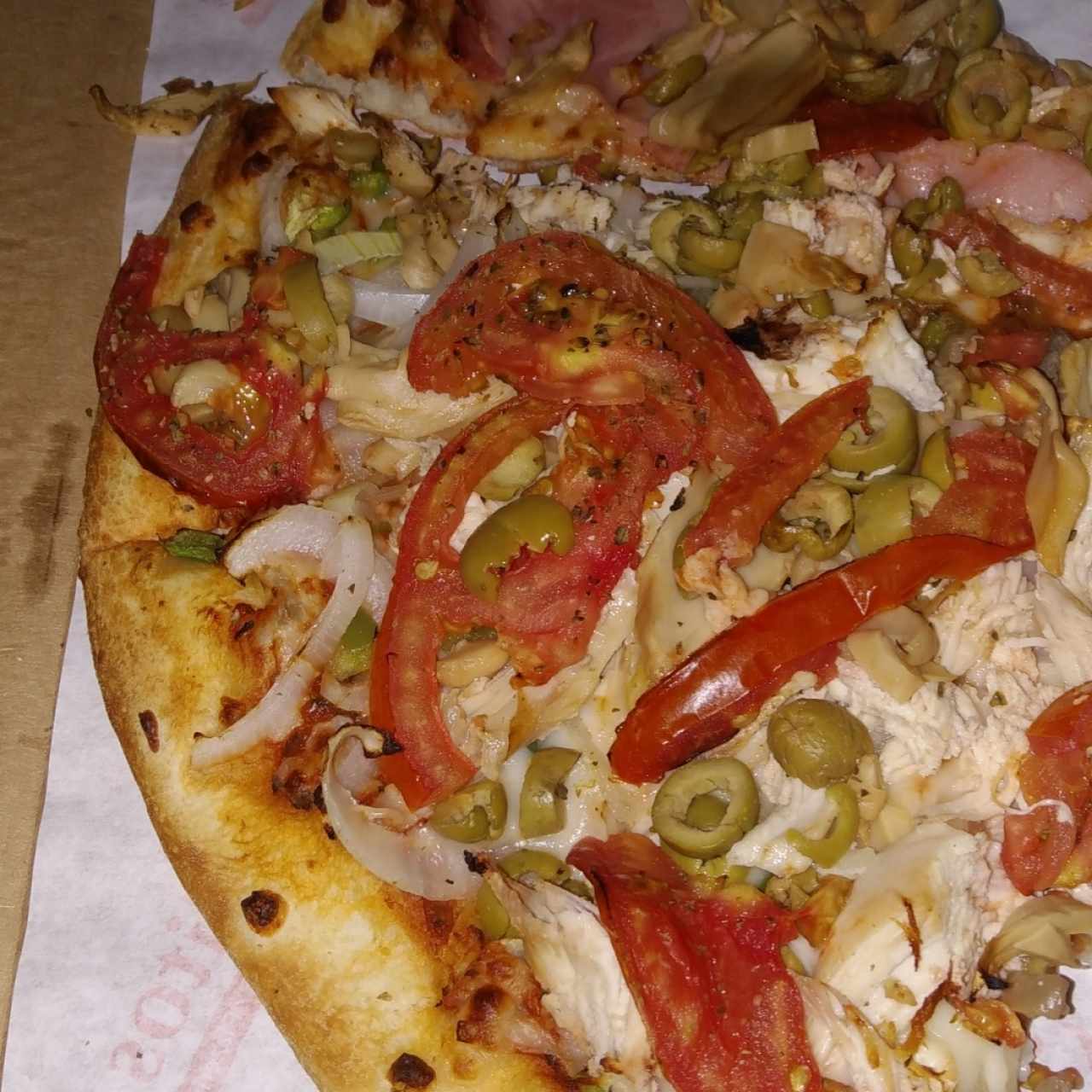 Pizza familiar de combinación, con extra de pollo y tomate.
