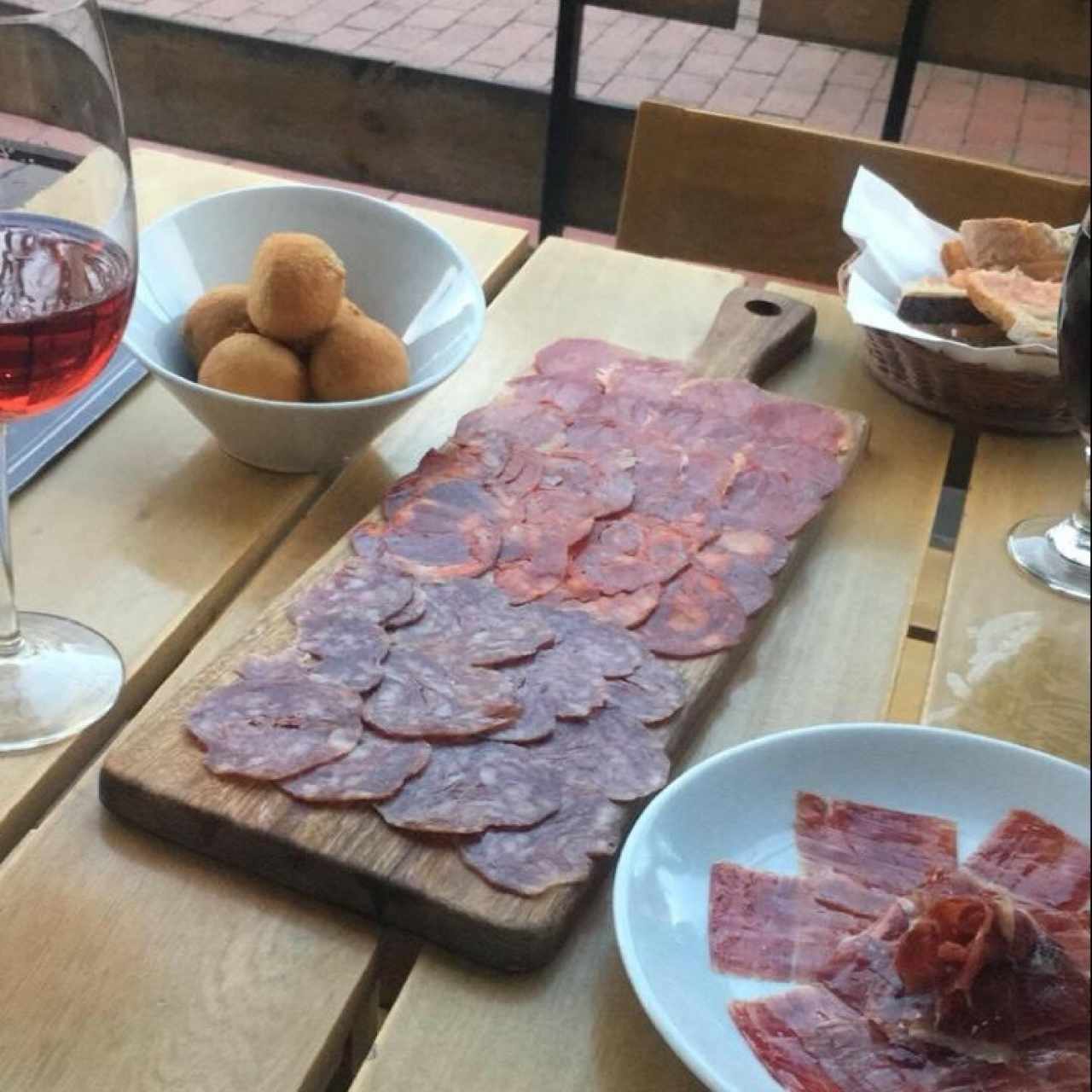 Tabla de jamones ibericos, croquetas de jamon iberico y queso manchego gratinado (lo sirven en tostadas españolas), todo acompaño de vino rosado. 