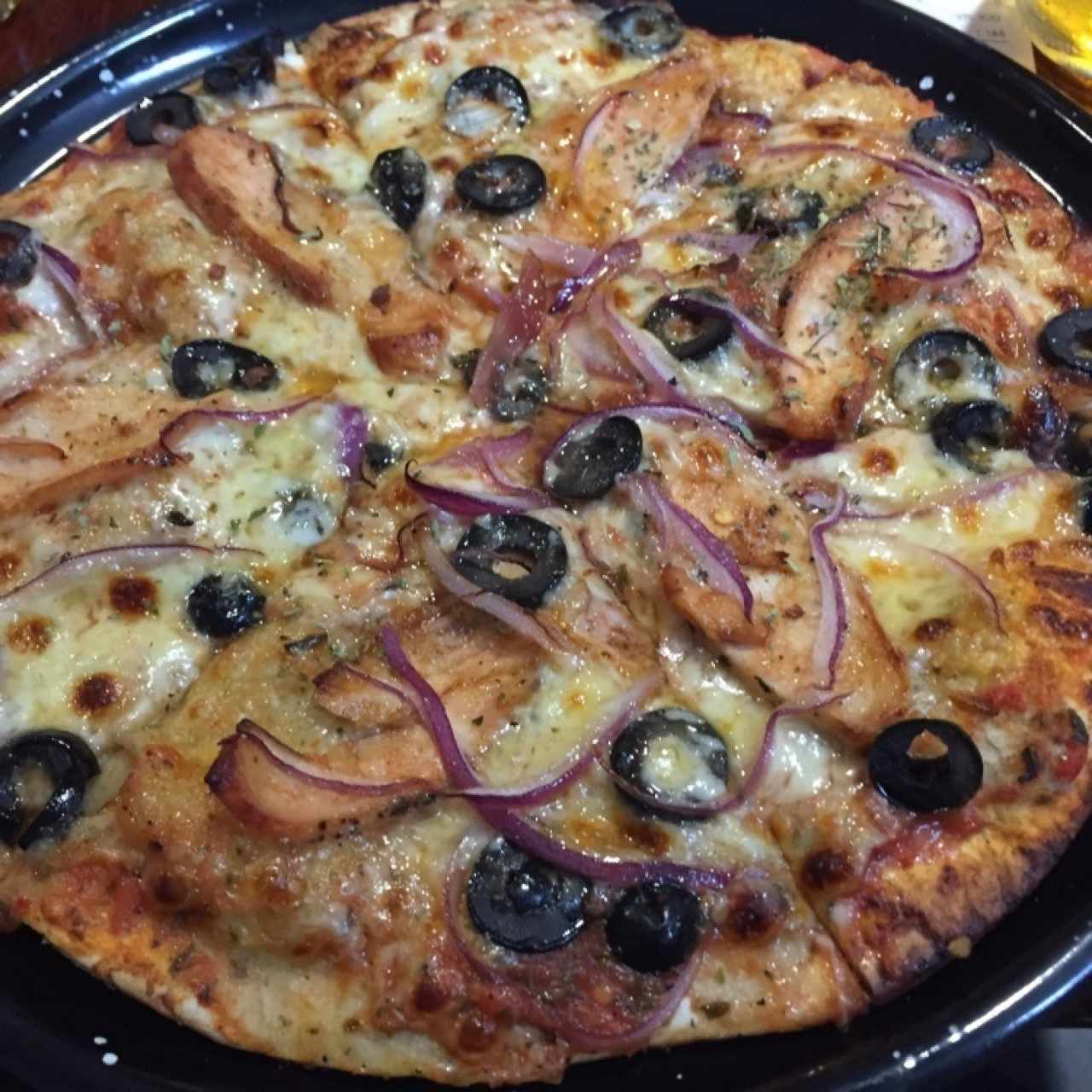 pizza de pollo bbq, aceitunas y cebolla en masa de orégano