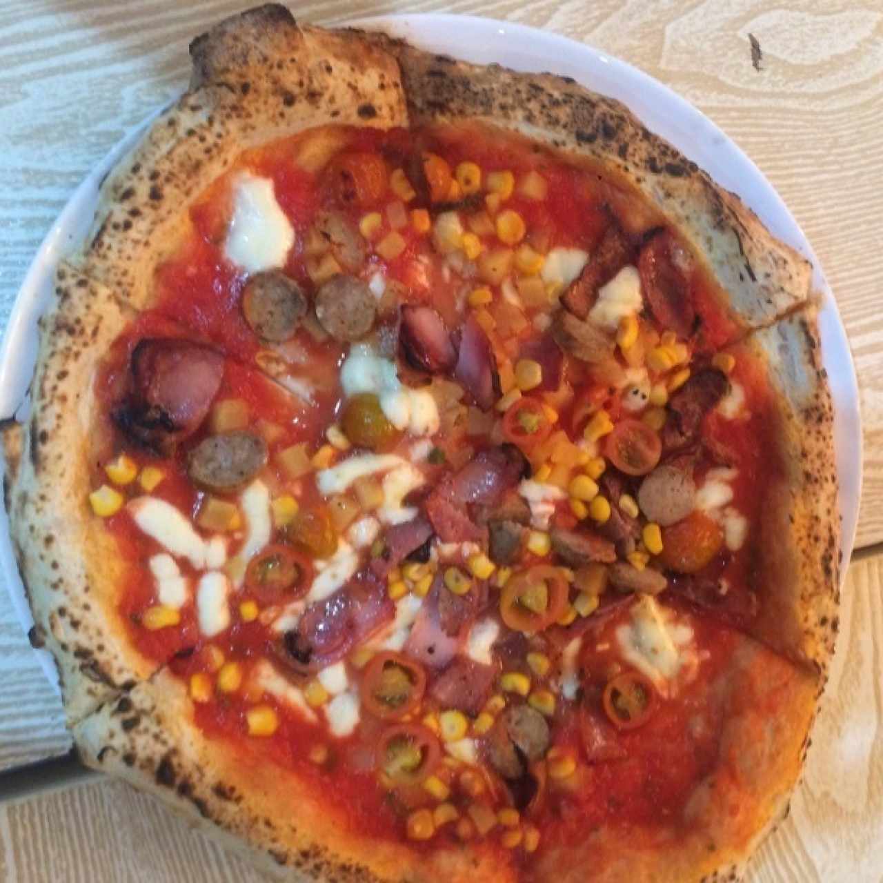Pizza personalizada: pasta de tomate, queso bufala, maíz, piña, salchicha italiana, tomate cherry, tocineta
