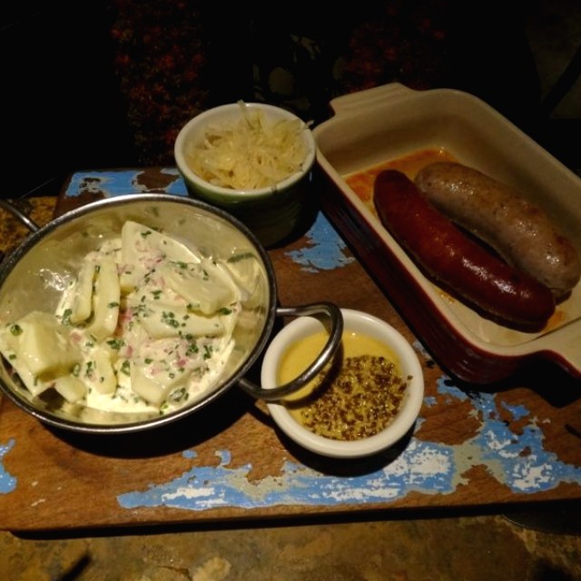 Salchichas hechas en casa, ensalada de papa alemana, mostaza y Sauerkraut