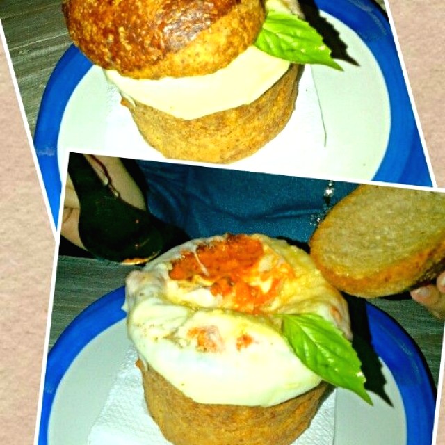 Sopa de tomate, servida dentro de un pan sellado con clara de huevo, cubierta de queso y adornada con una hojita de albahaca