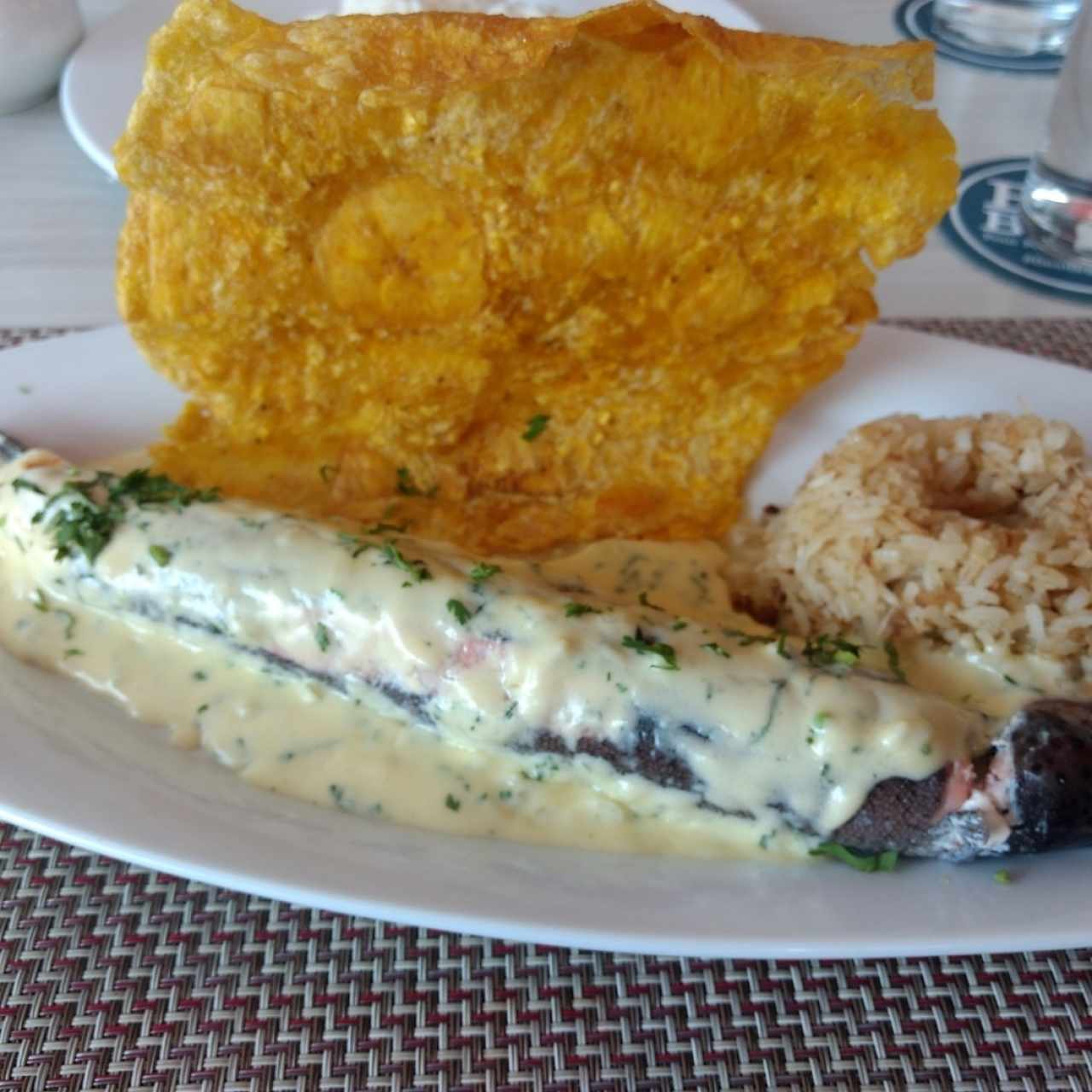 Trucha rellena con mariscos, arroz con coco y tostada valluna.