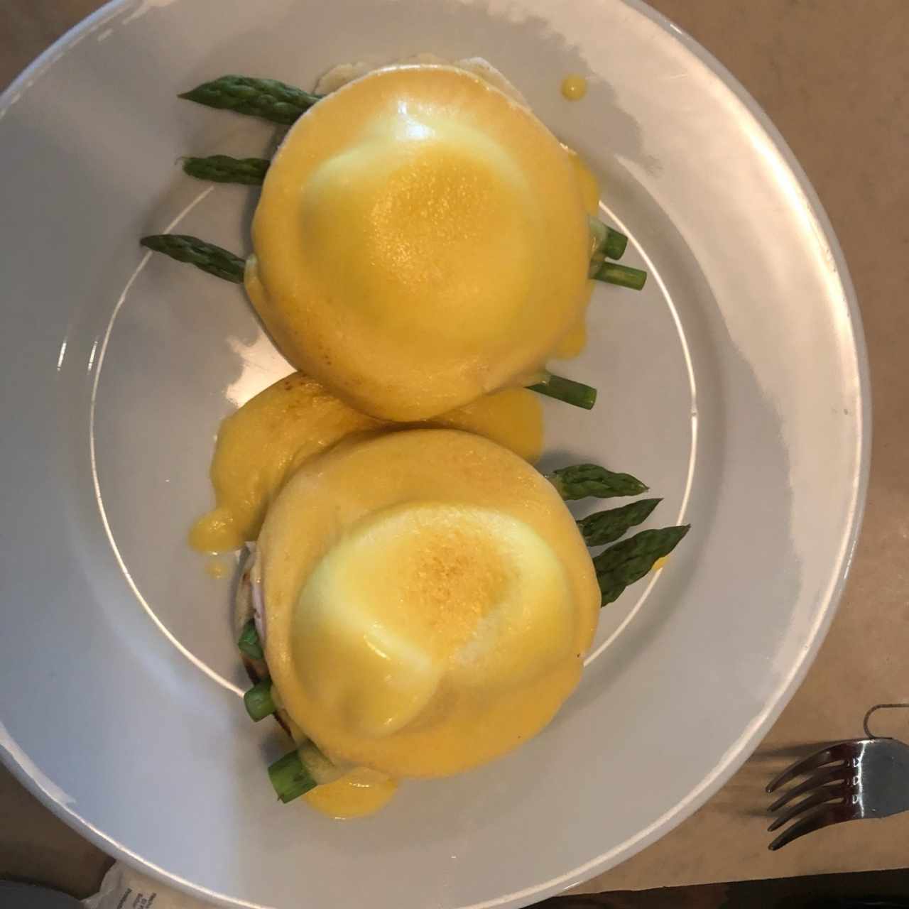 Deliciosos huevos benedictinos en cama de arepa pelada
