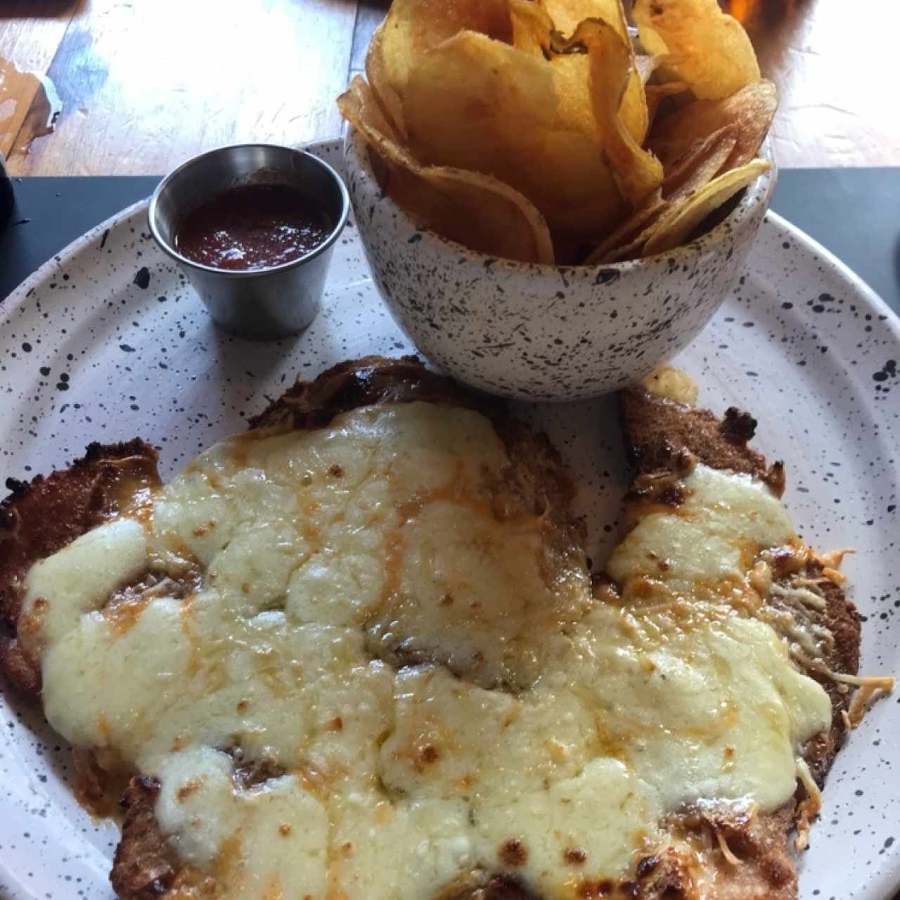 Milanesa mediana triple queso con papas chips y salsa napolitana