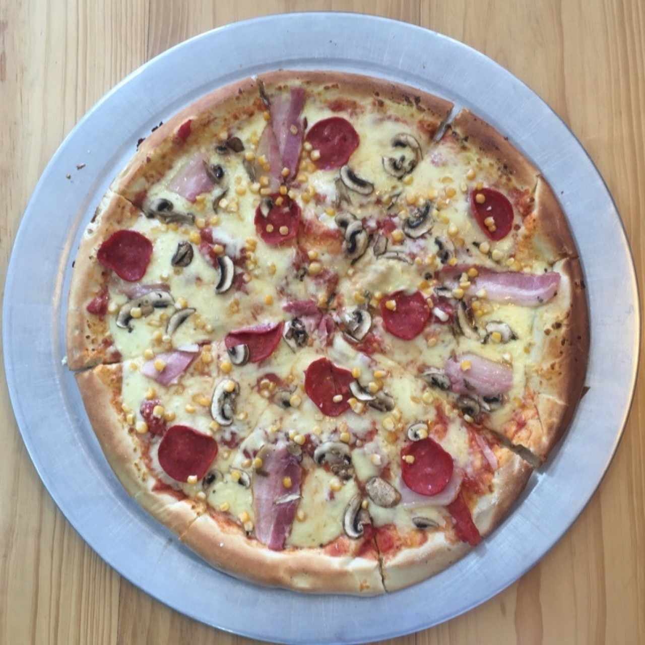 Pizza grande con pepperoni, champiñones, tocineta y maíz