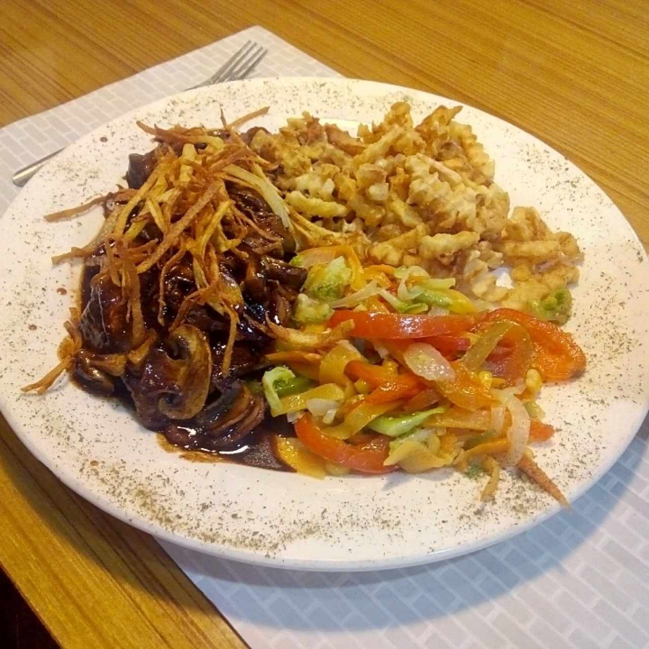 Filete mignon con papas fritas y vegetales salteados