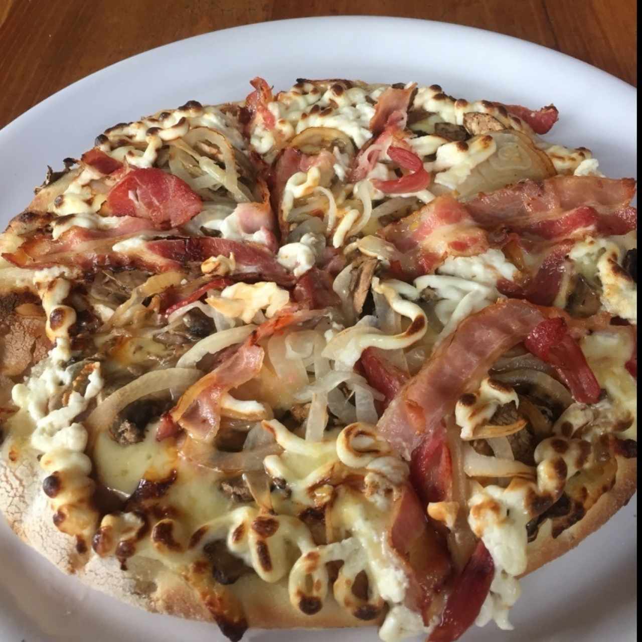 Pizza con queso crema tocineta y cebolla