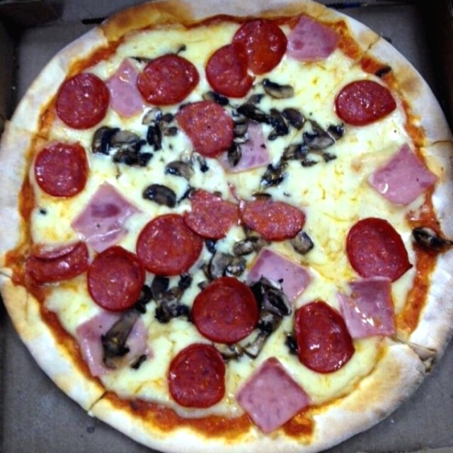 Rica pizza con pepperoni y champiñones para llevar. 