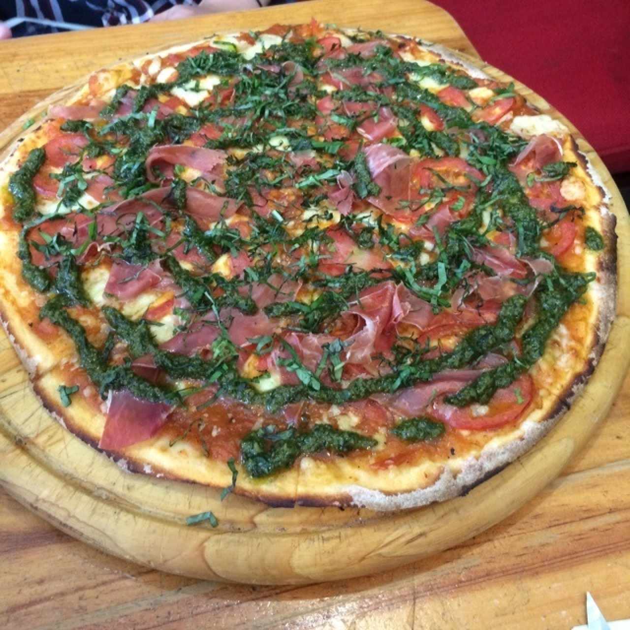 Pizza con pesto, tomate y jamon serrano